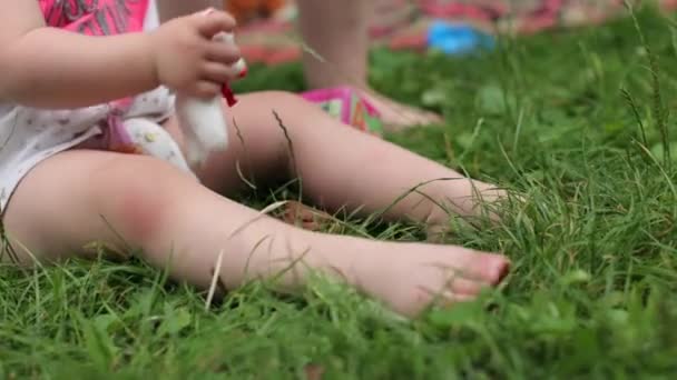 草の上に素足の少女 暑い夏と残りのサンダル 緑の草 子供のために 家の近くの芝生 草の上を裸足で歩くのが好き — ストック動画