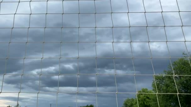 曇りの空の背景にあるバレーボールネット ホワイトネット バレーボール 悪天候のスポーツ ビーチゲーム 雷雨が近づいており 試合のキャンセル — ストック動画