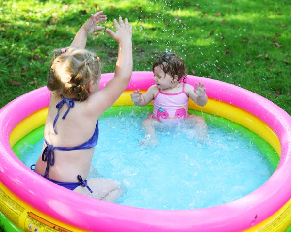 孩子们在游泳池里 夏天很热 一个小女孩 一个孩子在儿童游泳池里玩耍 在院子里游泳 在树阴下游泳 这个女孩喜欢水 穿着泳衣的快乐孩子 — 图库照片