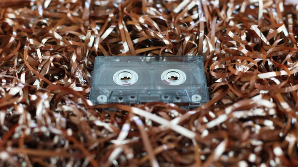 Audio cassette, on the background of the tape. Retro style, classic. Outdated equipment, a lot of film from cassettes. Cassette for radio, old music of 1970-1990 years. Vintage record, nostalgia
