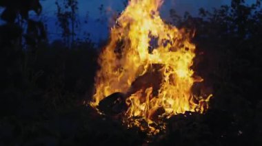 Büyük bir ateş, yakacak odun ve çöp yanıyor. Gece yangın çıktı, çevre kirliliği. Söndürmesi zor bir yangın. Uzun bir ateş sütunu..