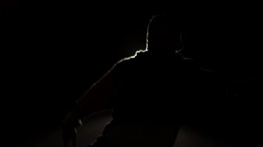 Hip hop dansı silueti. Karanlıkta dans eden, geceleri dans eden bir çocuk. İnsanlar dinamik hareketler yapar, modern tarzda. El fenerinin ışığı, evin yakınındaki şehirde dans ediyor.