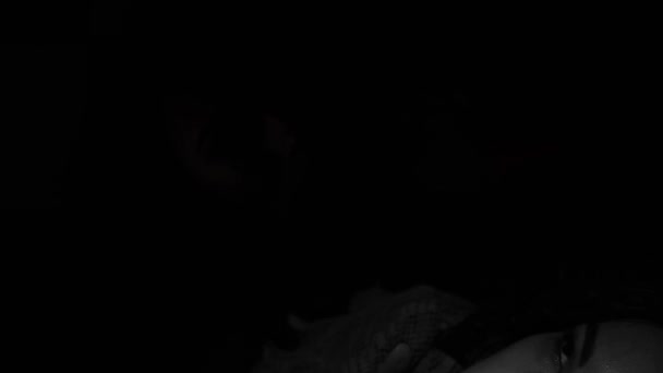 布鲁内特女孩万圣节风格 一个黑色背景的女人脸上闪烁着光芒一个可怕的场景可怕的黑暗 犯罪黑色狂欢节 在地下室 — 图库视频影像