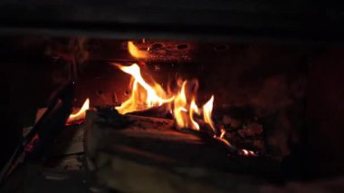 Şöminenin yanında bir gece. Şöminede bir alev yanıyor. Odun odayı ısıtır, oda sıcaktır, evin rahat bir köşesi olur.