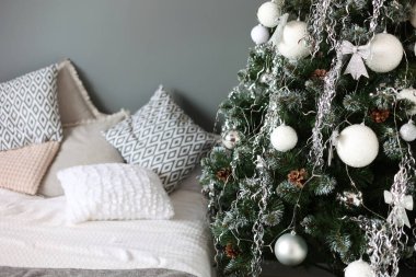Yılbaşı odası, yatak ve Noel ağacı. Noel, kış süslemeleri. Noel oyuncakları, toplar, tatiller. Mutlu yıllar.