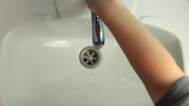 洗澡间里洗手的特写 水龙头里的干净水 一个女人洗了手 白色水池 保持个人卫生 不含细菌 — 图库视频影像