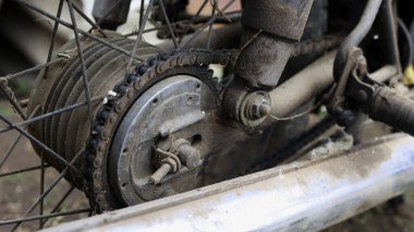 Eski motosiklet toz içinde. Kırmızı retro moto. Arızalı motosiklet, tamire ihtiyacı var. Kirli bir kırsal benzinli motosiklet, hemen yanındaki çöplükte.