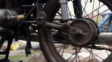 Eski motosiklet toz içinde. Kırmızı retro moto. Arızalı motosiklet, tamire ihtiyacı var. Kirli bir kırsal benzinli motosiklet, hemen yanındaki çöplükte.