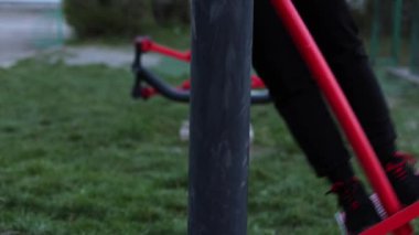 Avluda simülatör eğitimi. Kız kilo veriyor, motivasyonu var. Spor sahası, siyah eşofmanlı bir kadın egzersiz yapıyor. Açık hava sporları, sağlıklı yaşam tarzı.