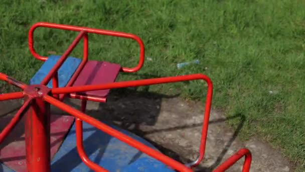 一个小女孩正在操场上玩耍 在公共场所的娱乐活动 孩子在新鲜空气中休息 她骑在一条小旋转木马上 — 图库视频影像