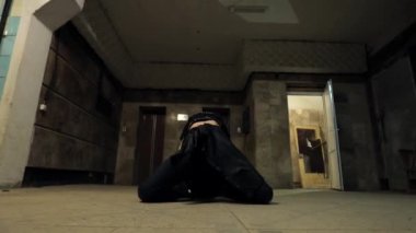 Gotik tarzda bir kız, yüzünde makyaj var. Siyahlı çekici esmer kadın. Korkunç bir odada kameranın önünde dans eden genç bir kadın. Güzel model koreograf, dramatik sahne