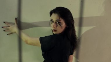 Gotik tarzda bir kız, yüzünde makyaj var. Siyahlı çekici esmer kadın. Genç bir kadın eski bir odada kameraya poz veriyor. Güzel model, dramatik sahne