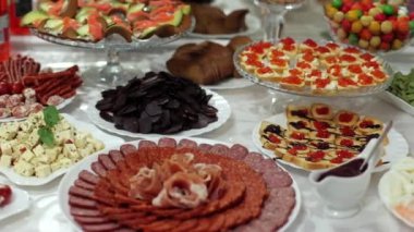 Lezzetli bir açık büfe, bir sürü farklı aperatif. Bir Ukrayna düğününde bir Kazak masası, çeşitli et yemekleri, yetişkinler için lezzetli bir eğlence. Şenlikli büfe, güzel dekore edilmiş et.
