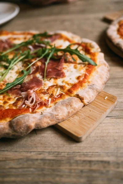 Delicious hot meat pizza with prosciutto and salami on a wooden table. High quality photo