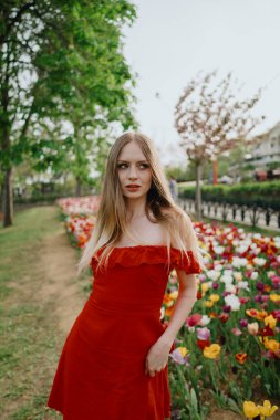 Baharda lalelerin arasında kırmızı elbiseli bir kız. Yüksek kalite fotoğraf
