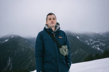 Kış dağlarının arka planında mutlu bir adam. Yüksek kalite fotoğraf