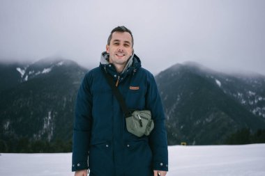 Kış dağlarının arka planında mutlu bir adam. Yüksek kalite fotoğraf