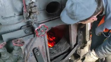 Yanan kömürlü lokomotif şöminesi.