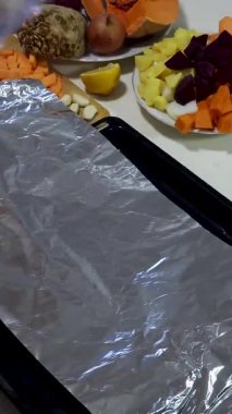 Bir birey sağlıklı atıştırmalıklar için bir masada çeşitli canlı meyve ve sebzeleri ustalıkla keser ve organize eder. Düzenleme ananas, havuç ve daha fazlasını içeriyor..