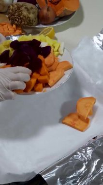 Renkli meyve ve sebze gibi malzemeler temizlenmek için eldiven kullanırken düzenleniyor. Konferansta sağlık ve yemek hazırlığı üzerinde duruluyor..