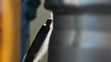 Yetenekli bir teknisyen, iyi donanımlı bir atölyede, öğleden sonraları metalcilik teknikleri ve makine işlemleri üzerine hassas bir kesme aleti kullanır..