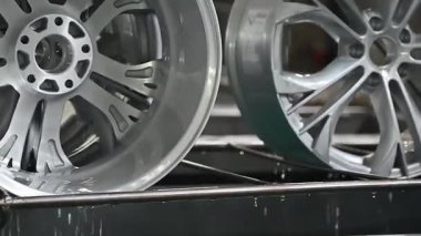İşçiler son model bir otomotiv tesisinde tekerlek imalat ekipmanlarını kullanırken görülüyor. Çevre faaliyet, hassasiyet ve zanaatkarlık ile dolup taşıyor..
