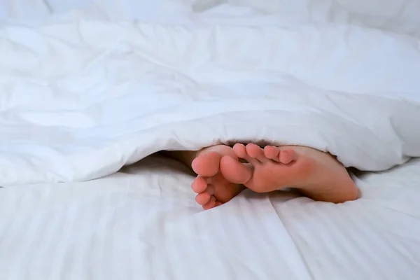Женщины Босиком Передвигают Ноги Комфортной Постели Среди Белого Белья Спит — стоковое фото