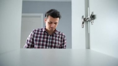 Genç adam elbiselerini dolabın rafına koyuyor, yakından bakıyor. Gardırop kapısını açıp kapatıyor, dolabın içinden ateş ediyor. Şehir dairesinde günlük yaşam ve rutin.