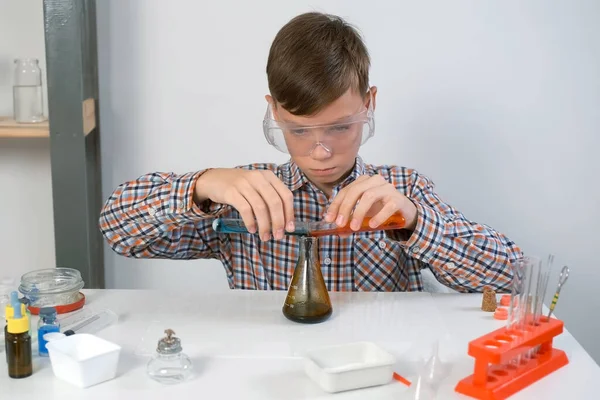 戴防护眼镜的少年正在做气体反应化学实验 他把苏打水 柠檬酸 蓝色和红色的液体混合在瓶中 网上教育 家庭教育和科学概念 — 图库照片
