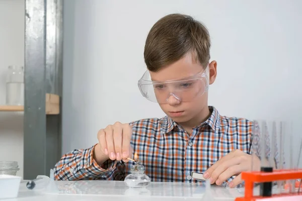 Tinédzser Fiú Védőszemüvegben Felgyújtja Égő Alkohollámpát Kémiai Kísérletekhez Online Oktatás — Stock Fotó