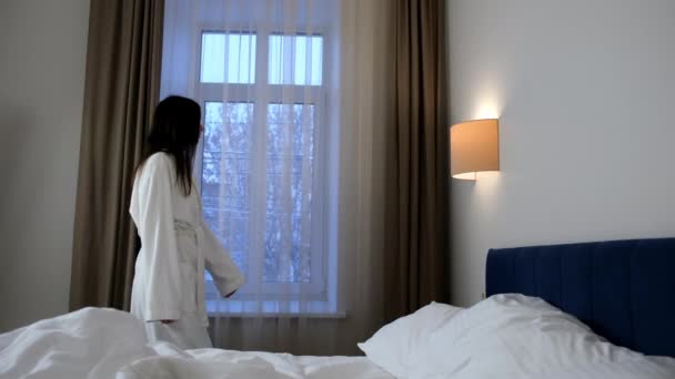 Brunette Jonge Eenzame Vrouw Witte Badjas Kijkt Naar Raam Hotelkamer — Stockvideo