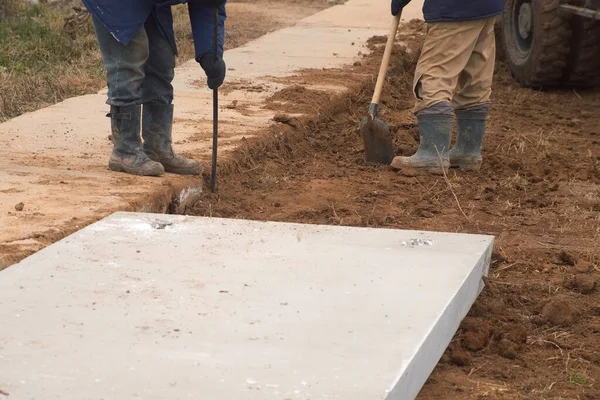 Dva Dělníci Lopatami Kopali Půdu Aby Položili Betonové Bloky Opravovali — Stock fotografie