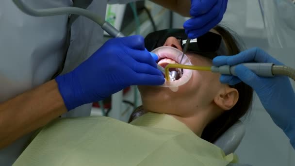 歯科医は ドリルを使用してセラミックベンダーとクラウンをインストールするための女性の歯を準備しています 彼は歯の一部のエナメル質を除去している 義肢の概念 歯医者による治療 — ストック動画
