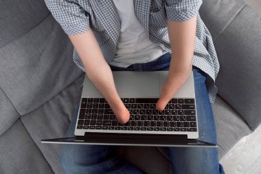 Elleri kesilmiş engelli bir adam dizüstü bilgisayarda çalışırken koltukta oturuyor, elleri kapalı. Engelli insanlara uyum sağlama sorunu. Bağımsız Bağımsız kişi.