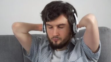 Kulaklıklı elleri kesilmiş engelli bir adamın portresi evde kanepede oturmuş müzik dinliyor. Engelli insanlara uyum sağlama sorunu. Bağımsız Bağımsız kişi.