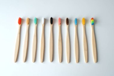 Beyaz arka planda bambudan yapılmış çevre dostu diş fırçaları. Biyolojik ayrıştırılabilir kişisel bakım ürünleri. Plastiksiz yaşam tarzı kavramı.