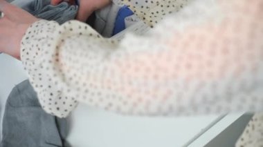 Kadınların elleri çorapları düzgünce katlayıp konteynırın içine koyuyor, yakından bakıyor. Eşyaları ve giysileri evde depolamanın bir yolu..