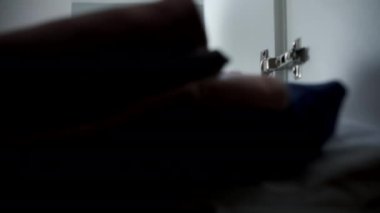 Genç gülümseyen mutlu kadın dolaptan giysiler alıyor, yakından bakıyor. Gardırop kapısını açıp kapatıyor, dolabın içinden ateş ediyor. Şehir dairesinde günlük yaşam ve rutin.