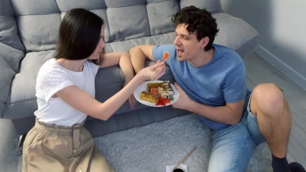 Ein Junges Glückliches Paar Mann Und Frau Isst Gemeinsam Sushi — Stockvideo