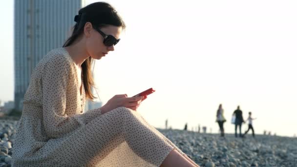 Mulher Que Navega Smartphone Sentado Costa Mar Seixos Cidade Batumi — Vídeo de Stock