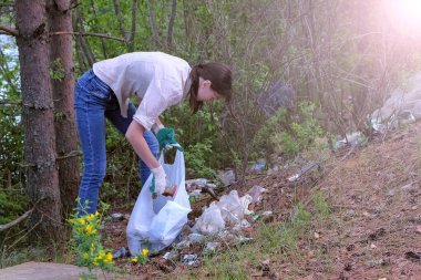 Parktaki göl kenarındaki çöpleri toplayan gönüllü bir kadın. Doğada bahar temizliği. Çevrenin insan tarafından kirlenmesi. Orman ve ekoloji sistemiyle ilgileniyor..