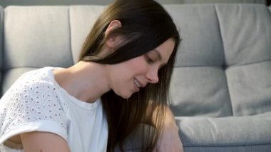 Gülümseyen genç bir kadının portresi oturma odasında ahşap çubuklarla suşi yiyip kameraya bakmaktır. Japon ve Çin yemekleri ve eve servis..