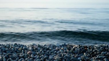 Çakıl taşı plajı ve mavi renkli deniz dalgalarıyla doğa deniz manzarası. Sessiz bir akşam. Sahilde dinlenme yeri. Turizm, seyahat, seyahat şehveti, tatil konsepti. Taşlarla dolu kıyı şeridi.