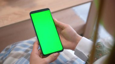 Sosyal medyada internet üzerinden akıllı telefon kullanan bir kadın. Mobil uygulamaları ya da web sitelerini gösterme, internette gezinme. Telefonla boş zamanlarımda dinleniyorum..