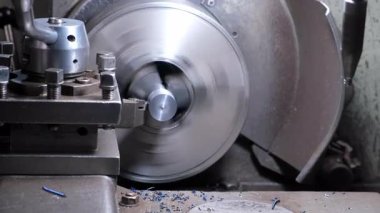 Otomatik torna makinesi fabrika atölyesinde metal parçaları döndürüyor ve şekillendiriyor. Metal parçacıklar parça parça uçuyor. Metalurji endüstrisi, otomatikleştirilmiş makine üretimi.