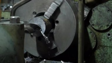 Sanayi torna makinesi santralde dönen metal silindir detayı. Kıvrımlı yay metal talaşları uçuşuyor. Metalurji endüstrisi, otomatikleştirilmiş makine üretimi.