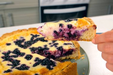 Yakın plan kesim kremalı turta ve yaban mersinli pasta. Bıçakla, yakın plan çekimle. Malzeme tarifi aşçılığı. Ev yapımı yemek fırını. Tatlı hazırlıyorum..