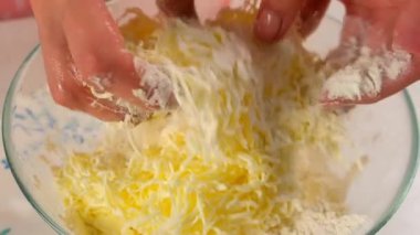 Kadın elleri mutfakta rendelenmiş tereyağla un ekmeği hamurunu karıştırıyor. Yemek tarifi mutfağı malzemesi. Pişirme, tatlı hazırlama, ev yapımı taze yemek. Taze yemek, pasta yap..