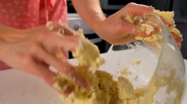 Kadın elleri yoğurulmuş ekmek hamurunu karıştırıyor mutfakta turta ya da kurabiye yapıyor. Yemek tarifi mutfağı malzemesi. Pişirme, tatlı hazırlama, ev yapımı taze yemek. Taze yemek, pasta yap..