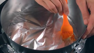 Bir kadın fırında turta kurabiyesi pişirmek için tereyağı sürüyor. Evdeki mutfakta yemek hazırlayan kadın elleri. Malzeme tarifi aşçılığı. Ev yapımı, lezzetli yemekler, pişirme..